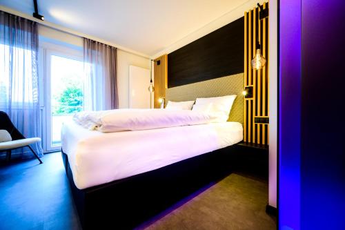 a bedroom with a large bed and a window at Aqua Blu Hotel in Bad Füssing