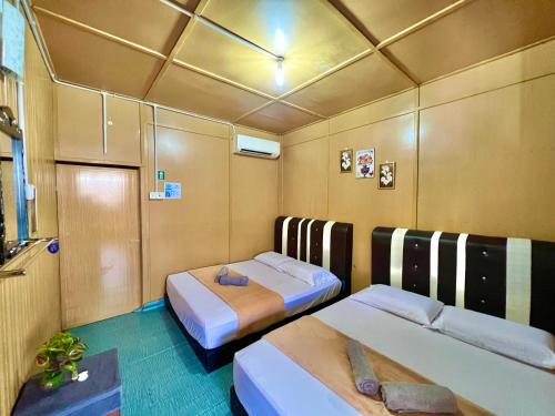 a room with two beds in a room with at Perhentian Sri Tanjung , Kampung Nelayan Pulau Perhentian in Perhentian Island