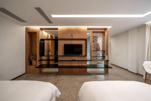 a hotel room with two beds and a television at 慢境Slow Land半山海景花园酒店 in Dali