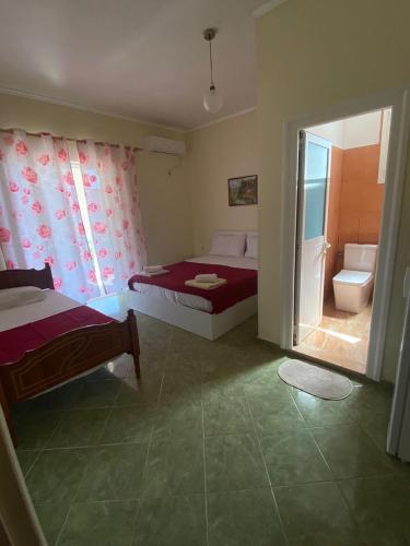 a small bedroom with two beds and a bathroom at Vila zaho in Dhërmi