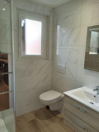 une salle de bain avec toilettes, lavabo et fenêtre dans l'établissement Cité de la Gastronomie, à Dijon