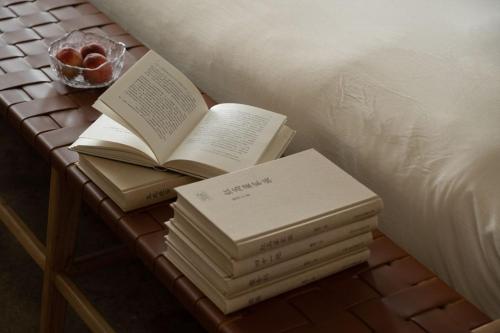 a pile of books on a table next to a bed at 慢境Slow Land半山海景花园酒店 in Dali