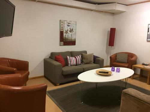 a living room with a couch and a table at Tylebäck - boende med självhushåll in Halmstad
