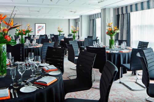 a conference room with tables and chairs and flowers at Leicester Marriott Hotel in Leicester