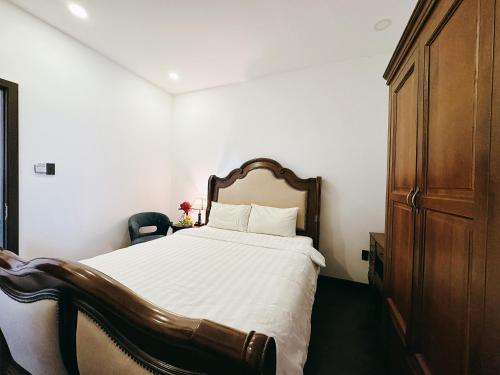 a bedroom with a large bed and a wooden cabinet at TTR Joy Apart' Hotel in Da Lat