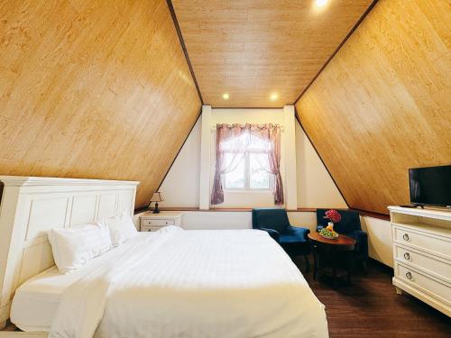 a bedroom with a white bed and a wooden ceiling at TTR Joy Apart' Hotel in Da Lat