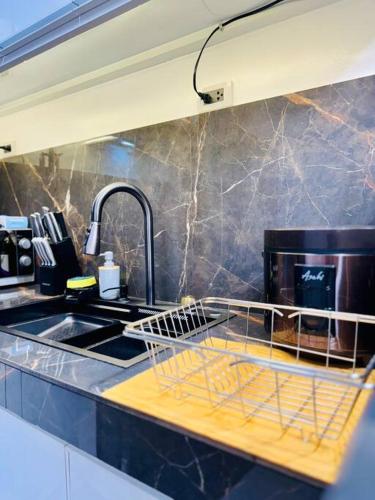 a kitchen with a sink and a dish drying rack at La Prima - The Perfect Urban Oasis in Santa Rosa