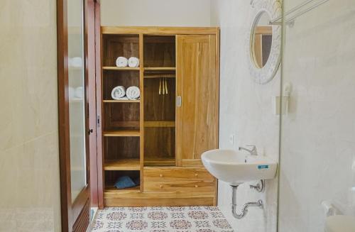 a bathroom with a sink and a wooden cabinet at Pondok Talavana in Badung