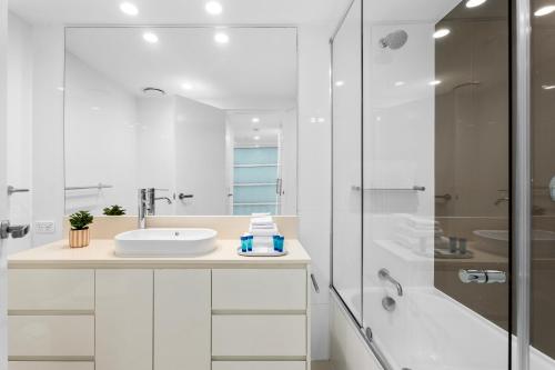 a white bathroom with a sink and a shower at H-Residences - Gclr in Gold Coast