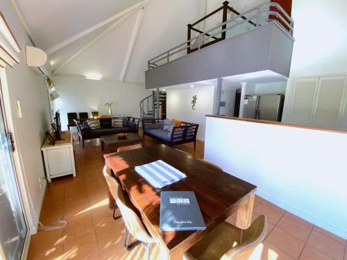 a living room with a table and a loft at Osprey Holiday Village Unit 112 in Exmouth