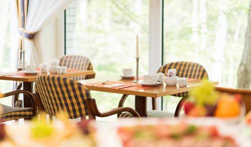 ein Esszimmer mit Tischen und Stühlen und einem Fenster in der Unterkunft Bel Air Strandhotel Glowe in Glowe