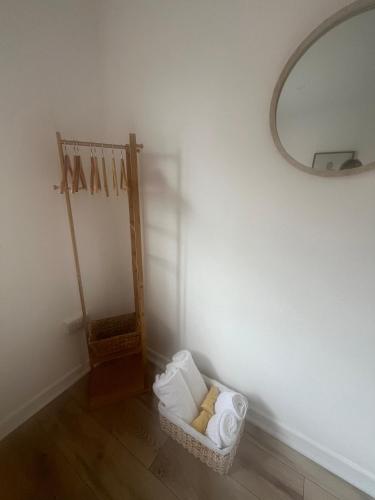 a bathroom with a mirror and a basket of towels at Hazlebury Muse in Broadstone