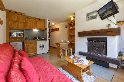 - un salon avec un canapé rouge et une cheminée dans l'établissement Appartement Central Des Houches - 15 - Happy Rentals, aux Houches
