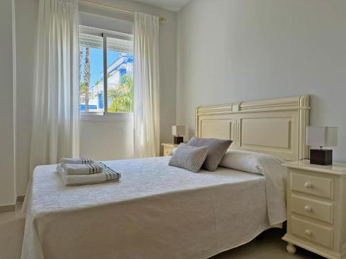 une chambre blanche avec un grand lit et une fenêtre dans l'établissement Apartamento Playa Ballena - Ole Solutions, à Costa Ballena