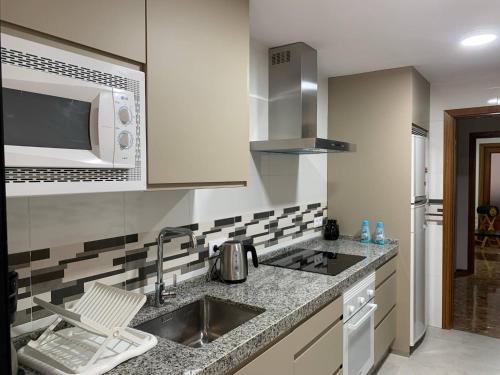 kuchnia ze zlewem i mikrofalówką w obiekcie Apartamento Galeón - Ole Solutions w mieście El Puerto de Santa María
