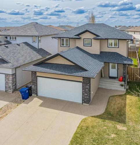 a large house with a white garage at Spacious 4BR-4BA House for Large Families & Group in Stonebridge in Saskatoon