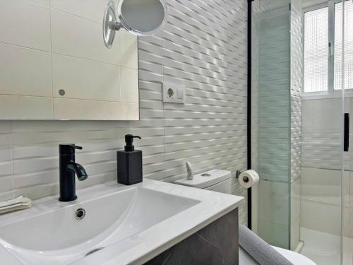 un bagno bianco con lavandino e doccia di Apartamento Acebuche - Ole Solutions a Jerez de la Frontera