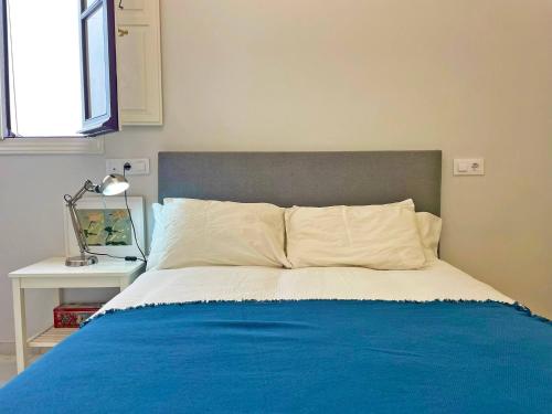 a bedroom with a bed with a blue blanket at Apartamento Villamarta - Ole Solutions in Jerez de la Frontera