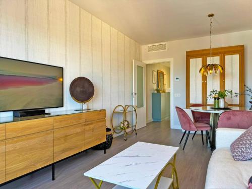 un soggiorno con TV a schermo piatto su un comò in legno di Apartamento Moscatel - Ole Solutions a Jerez de la Frontera
