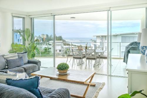 a living room with a couch and a table at Hamptons Style Penthouse at Kings Beach in Caloundra