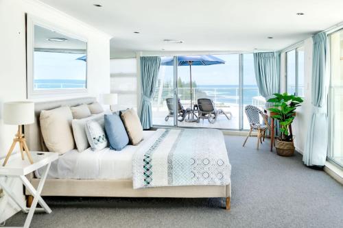 a bedroom with a bed and a view of the ocean at Hamptons Style Penthouse at Kings Beach in Caloundra