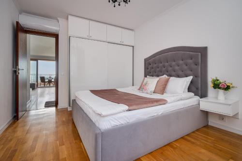 a bedroom with a large bed with a gray headboard at Queen's view 14-Pools-Near Botanic garden in Balchik
