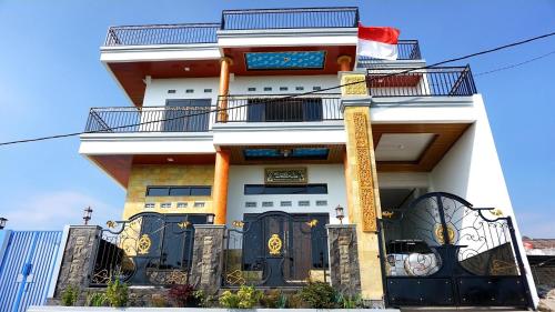 a white building with black doors and a balcony at Villa Hasanah in Subang