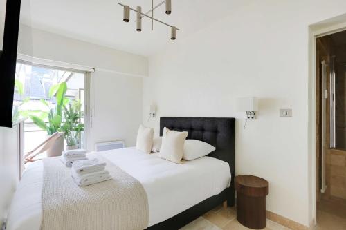 une chambre blanche avec un lit avec des serviettes dessus dans l'établissement Chic apartment - 1BR-4P - Place des Vosges, à Paris