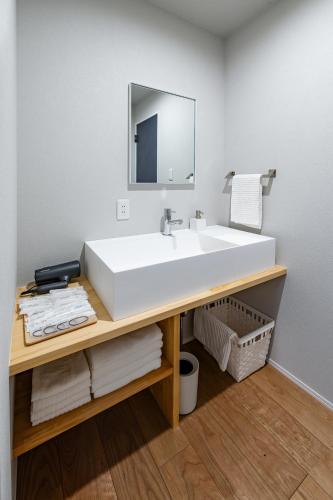 a bathroom with a white sink and a mirror at BATEAU rental vacation in Awaji