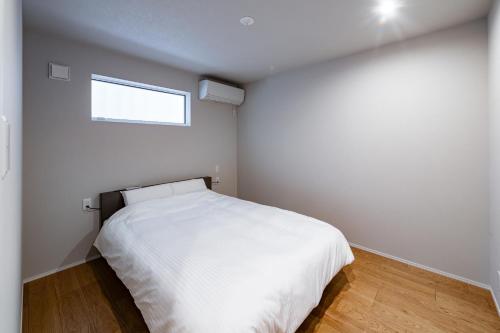 a bedroom with a white bed and a window at BATEAU rental vacation in Awaji