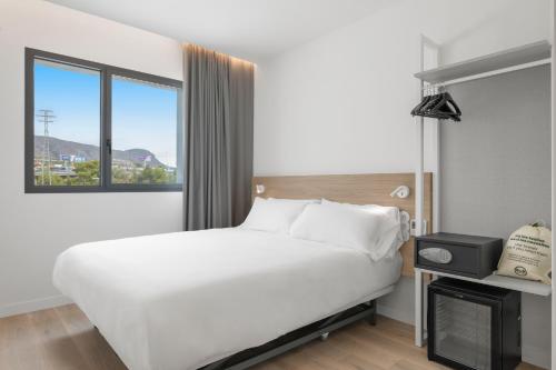 a hotel room with a bed and a window at B&B HOTEL Benidorm Finestrat in Finestrat