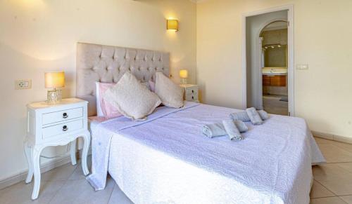 a bedroom with a large bed with purple sheets and pillows at Villa Victoria With Heated Pool in Callao Salvaje