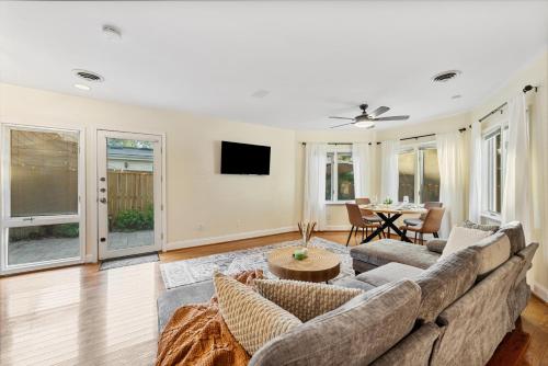 a living room with a couch and a table at Patio Paradise Stylish 3BR Home with Gaming Room in Arlington