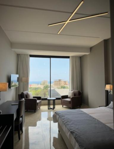 a bedroom with a bed and a living room at 365 UrbanLiving in Jbeil