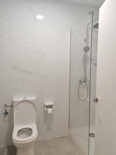 a bathroom with a toilet and a glass shower at Hotel Golden Alcorcon in Alcorcón