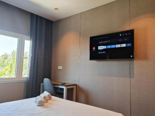 a room with a tv on a wall with a table at Hotel Golden Alcorcon in Alcorcón