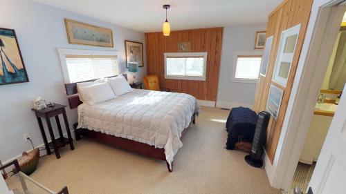 una camera da letto con un letto con lenzuola bianche e pareti in legno di Northside Hideaway Exquisite1-Bedroom House, Quiet Street, a Bozeman