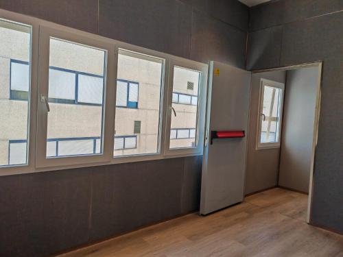 an empty room with three windows and a door at Hotel Golden Alcorcon in Alcorcón