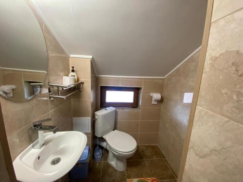 a bathroom with a white toilet and a sink at Анелия in Sapareva Banya