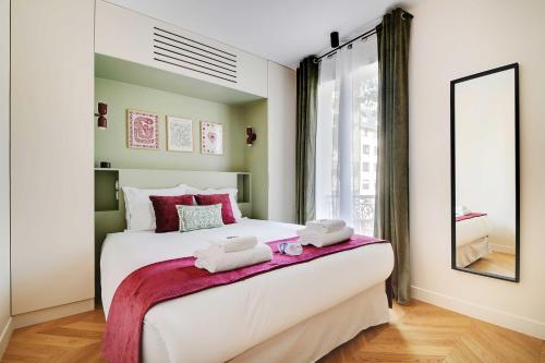 une chambre avec un grand lit avec des serviettes dessus dans l'établissement Parisian with air conditioning Eiffel Tower, à Paris