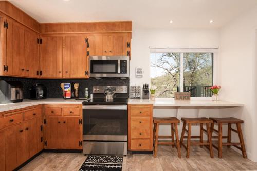 a kitchen with wooden cabinets and a stove top oven at Buckeye Bungalow w hot tub/firepit/views Pet Friendly in Oakhurst