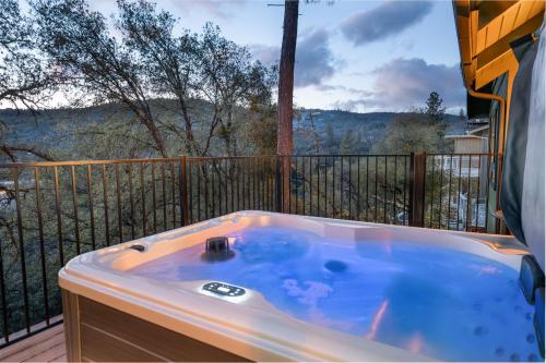 a jacuzzi tub on a balcony with a view at Buckeye Bungalow w hot tub/firepit/views Pet Friendly in Oakhurst