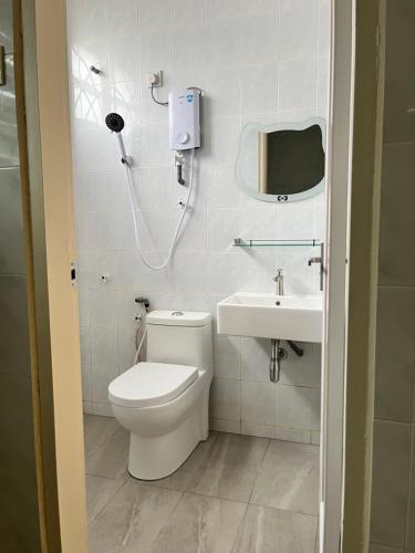 un baño con inodoro y lavabo en Blossom Hill homestay, en Kuantan