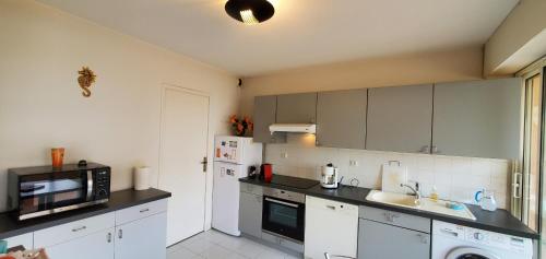 une cuisine avec des armoires blanches et un comptoir noir dans l'établissement ROSA BAIA Rare 110m2 , 3 chambres, Vue mer, 6 pers, à Fréjus