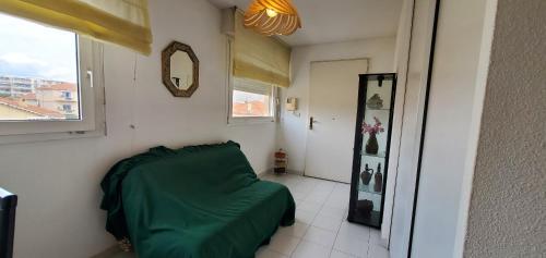 - une chambre avec un lit vert et un miroir dans l'établissement ROSA BAIA Rare 110m2 , 3 chambres, Vue mer, 6 pers, à Fréjus