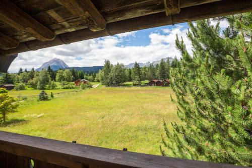 a view of a field from a house window at Bichlhof Appartements, mit Wellness im Hotel Charlotte in Seefeld in Tirol