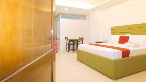 a bedroom with a bed and a table at RedDoorz at EBM One Building in Iloilo City