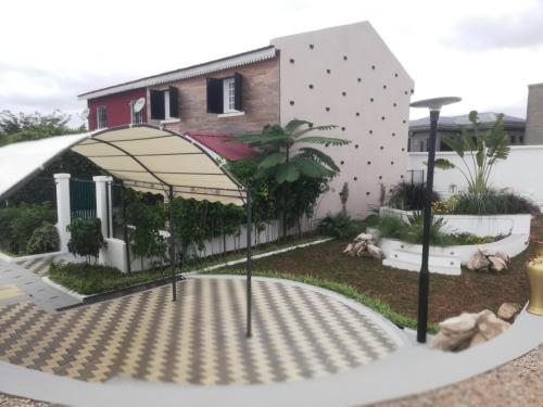 a building with a canopy in front of a yard at Résidence La Tonnelle in Antananarivo