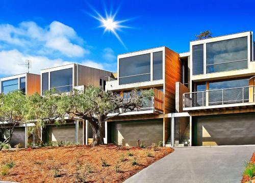 an apartment building with a tree in front of it at Long Point Living in Merimbula