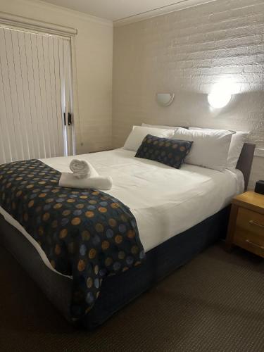 a bedroom with a large bed with pillows at Baywatch 5 in Merimbula